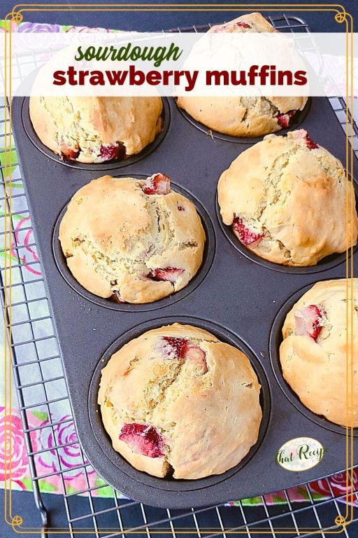 strawberry muffins in a muffin tin with text overlay "sourdough strawberry muffins"