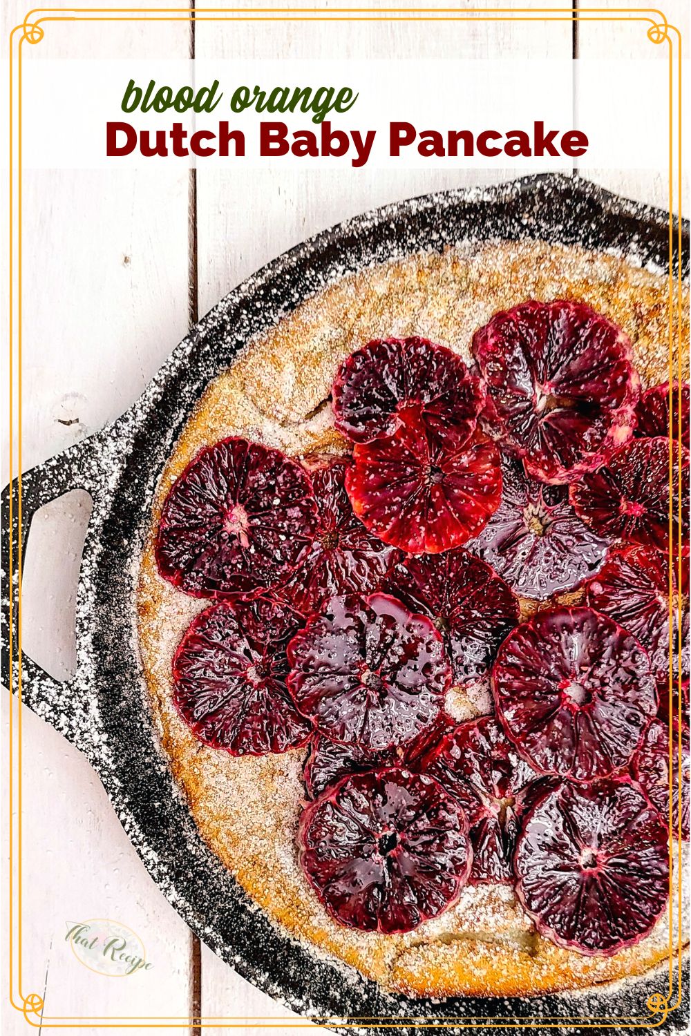 top down view of durch baby pancake in a cast iron skillet topped with blood orange slices and powdered sugar.