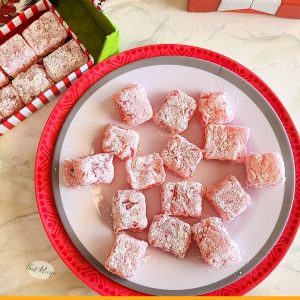 pink candies coated in powdered sugar on a plate