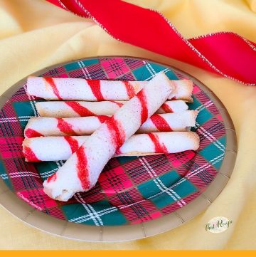 striped cookie rolls on a plate with text "peppermint rolled wafers"
