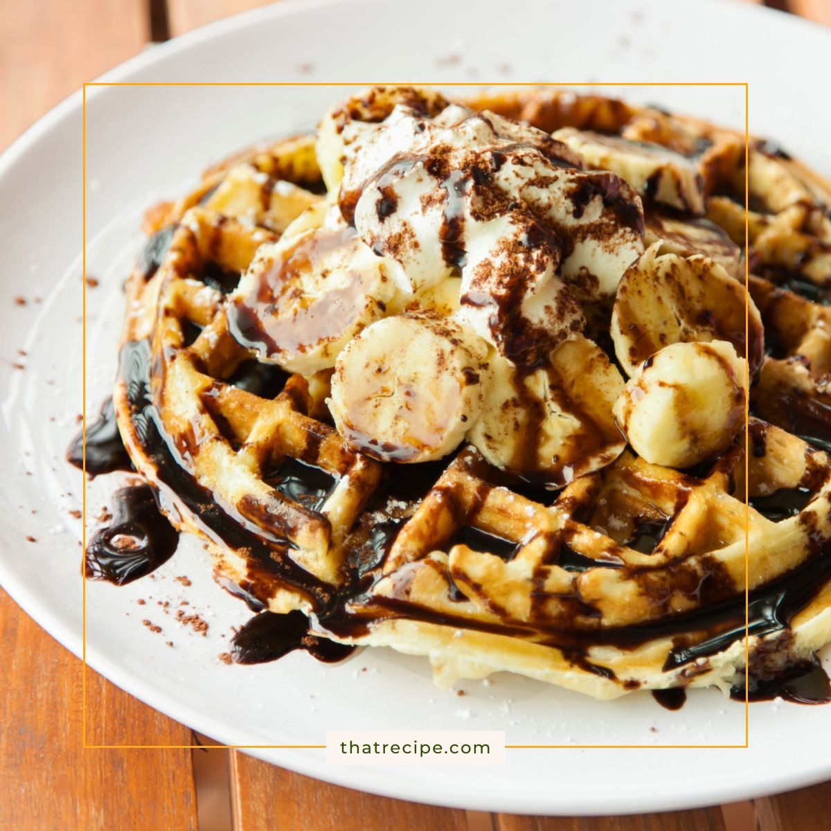 waffles on a plate topped with whipped cream, bananas and chocolate syrup.