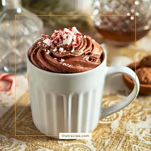 mug of hot chocolate topped with chocolate whipped cream and crushed candy canes