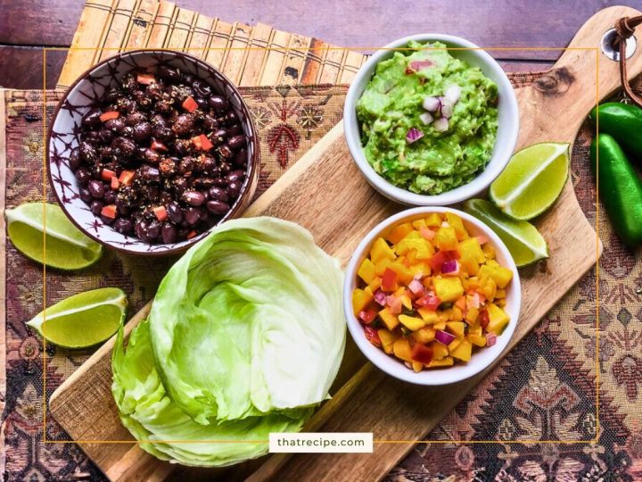 bowls of black beans, guacamole and mango salsa with lettuce leaves