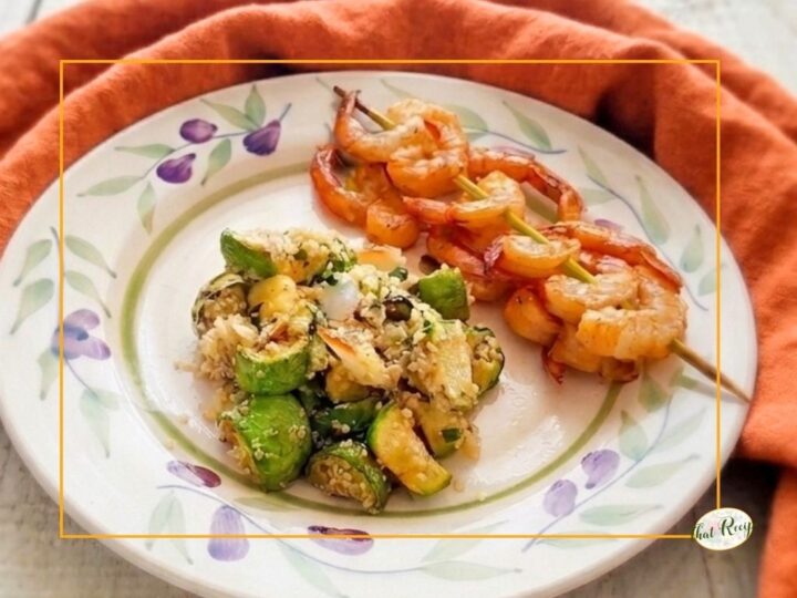 Summer Squash and Quinoa Pilaf or Salad on a plate with shrimp skewers.
