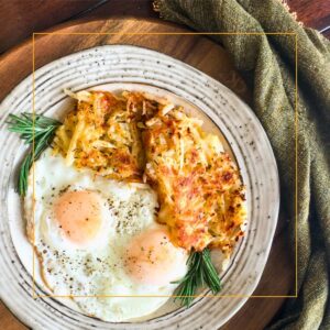 homemade hashbrowns on a plate with two eggs